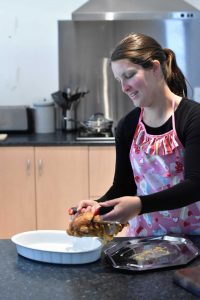 Lady using the Premiala meat claws to move roast chicken